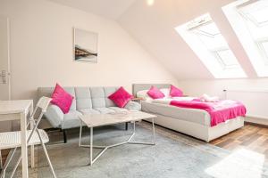 a bedroom with a couch and pink pillows at Airy Attic Apt.: Stylish Studio at Penzing Area in Vienna