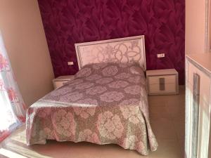 ein Schlafzimmer mit einem Bett mit einer lila Wand in der Unterkunft Albamar in Ciudad Quesada