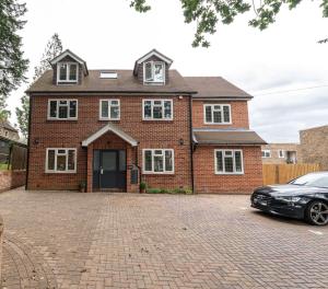 a brick house with a car parked in front of it at Elms House, sleeps 5, free parking in Reading