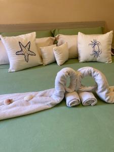 een handdoekenslang op een bed met kussens bij La Marina Apartment with Pool in Olbia