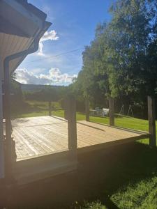 una terraza de madera con vistas a un parque en Hus i lugn och naturskön miljö en Ockelbo