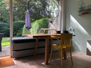 uma mesa e cadeiras num quarto com uma janela em Veluwe Nature Home - 2 persons em Otterlo