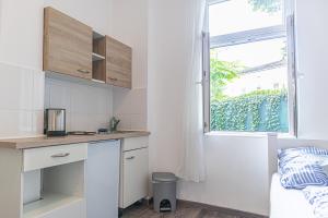 a small kitchen with a counter and a window at Brilliant 1BR Apt Comfortable Design/Near Schönbrunn in Vienna