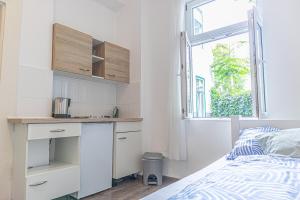 a bedroom with a bed and a desk and a window at Brilliant 1BR Apt Comfortable Design/Near Schönbrunn in Vienna