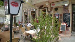 a group of people sitting at tables outside a restaurant at City Apartments Wien - Viennapartment in Vienna