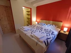 a bedroom with a bed and a red wall at The Green Turtle Eco Lodge in Willemstad