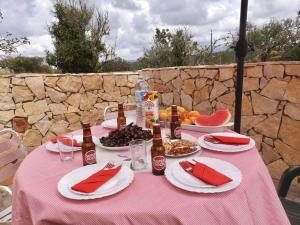 a table with a pink table cloth with food and drinks at Casa Manuel J. J. M -Alfambras, Aljezur - Quiet Country House in Aljezur