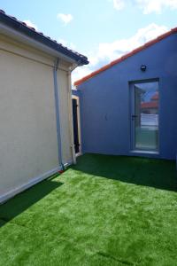 a yard with green grass next to a building at Chez Audrey & JD in Vertou