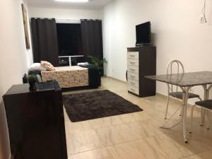 een woonkamer met een bed, een tafel en een bureau bij Lapa in Rio de Janeiro