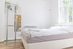 维也纳Astonishing 1BR Apt Easy Use Design/Near Schönbrunn的白色卧室配有一张床和淋浴