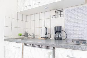 维也纳Astonishing 1BR Apt Easy Use Design/Near Schönbrunn的厨房配有水槽和台面上的咖啡机