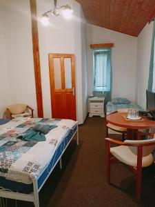 1 dormitorio con cama, mesa y escritorio en Rodinný penzion Barborka, en Hranice