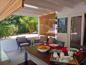 a dining room with a table with a bowl of fruit on it at The Green Turtle Eco Lodge in Willemstad
