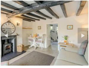 sala de estar con chimenea y reloj en la pared en Stone Cottage, Idyllic Village en Ingham