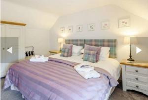 a bedroom with a large bed with two towels on it at Stone Cottage, Idyllic Village in Ingham
