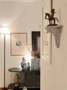una camera con lampada e mensola con statua di cavallo di La Villa Bianca - appartamento in villa a Sesto Fiorentino