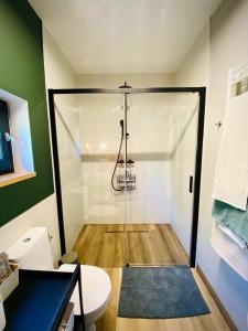 a shower with a glass door in a bathroom at Rajska nowoczesna stodoła !!! in Dźwierzuty