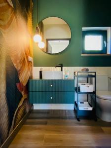 a green bathroom with a sink and a mirror at Rajska nowoczesna stodoła !!! in Dźwierzuty