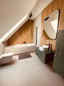 ein Badezimmer mit einem Waschbecken, einer Badewanne und einem WC in der Unterkunft Rajska nowoczesna stodoła !!! in Dźwierzuty