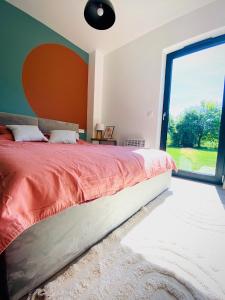 a bedroom with a large bed with a large window at Rajska nowoczesna stodoła !!! in Dźwierzuty
