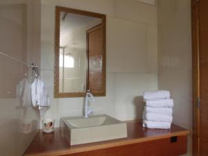a bathroom with a sink and a mirror and towels at Pousada dos Ventos in Penha