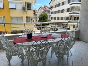 d'une table et de chaises sur un balcon avec un tissu de table rouge dans l'établissement Merkeze Yakın, Ev Rahatlığında, à Marmaris