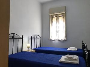 シャッカにあるS.Giorgio Apartmentsのベッドルーム1室(青いベッド2台、窓付)