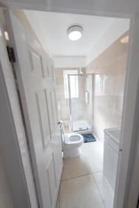 a white bathroom with a toilet and a shower at Entire House-Merseyside-Liverpool in Birkenhead