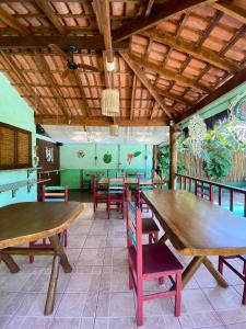 a dining room with wooden tables and chairs at Pousada Banana Verde in Ilhabela