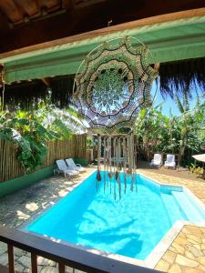 a swimming pool with a chandelier above it at Pousada Banana Verde in Ilhabela