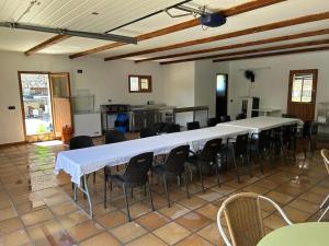 een kamer met tafels en stoelen en een keuken bij Casa Grande Del Pinar in Almorox