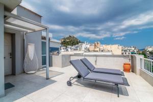 a lounge chair on the balcony of a house at Kolonaki Square Parthenon Τerrace in Athens