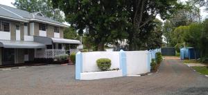 una cerca blanca frente a una casa en Trans-Africa equator hotel en Eldoret