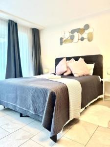 una camera da letto con un letto con una coperta blu e cuscini di Casa Ambizione a Dietikon