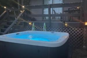 eine Badewanne mit blauem Wasser in einem Zimmer in der Unterkunft Lakeside Oasis with Kayaks, Hot Tub, & Fire Pit 