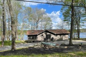 a small cabin in the woods next to a lake at Lakeside Oasis with Kayaks, Hot Tub, & Fire Pit in Clifton