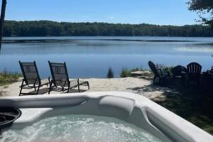 eine Badewanne mit Stühlen und einem Körper aus Wasser in der Unterkunft Lakeside Oasis with Kayaks, Hot Tub, & Fire Pit 