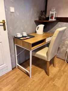 a wooden desk with a chair and a laptop on it at Hostel Homies Inn in Celiny