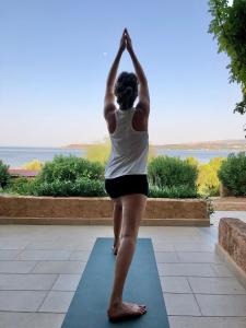 a woman doing yoga in front of a window at Galini Studios and Apartments in Lassi