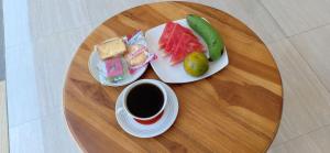 uma mesa com dois pratos de comida e uma chávena de café em Erwin's Guest Room em Sanur