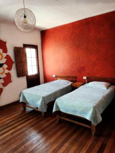 - 2 lits dans une chambre aux murs rouges dans l'établissement Joske, à Arequipa