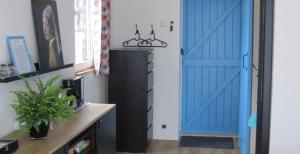 a blue door in a room with a desk at Het Schuurhuis in Stadskanaal