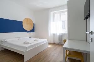 a white room with a bed and a table at Easylife - Esperienza unica nel cuore di Moscova in Milan