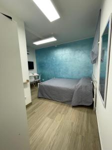 ein Schlafzimmer mit einem Bett und einer blauen Wand in der Unterkunft GG-Grow - La Terrazza Di Bellavista in Neapel