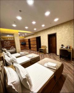 YakkasarayにあるAL ARDA HYATTのベッド4台、デスクが備わる客室です。