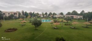 a park with a pool and umbrellas on a field at Résidence du golf in Fez