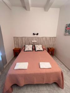 a bedroom with a large bed with two towels on it at Hostal mesón del cinca in El Grado