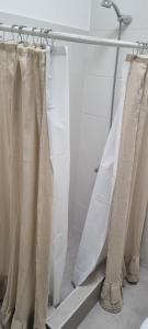 een douche met witte douchegordijnen in de badkamer bij Lacheli in Santa Rosa