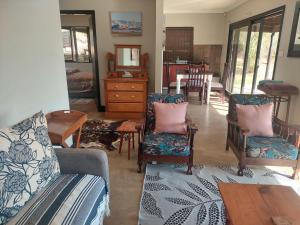 a living room with a couch and chairs and a table at 9 Stoney Way Cottage in Underberg