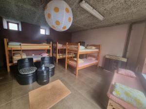 a room with bunk beds and a table and chairs at Albergue Gabino in El Ganso
